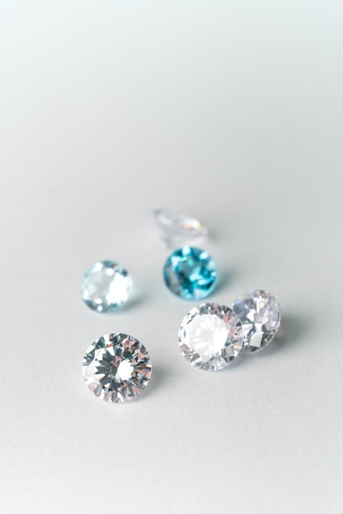 Close-up view of assorted sparkling gems on a white surface, showcasing brilliance.