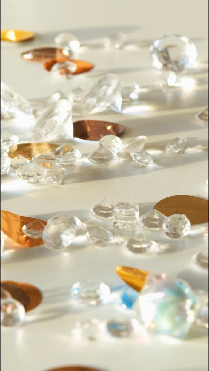 Elegant arrangement of gemstones reflecting light on a white surface.